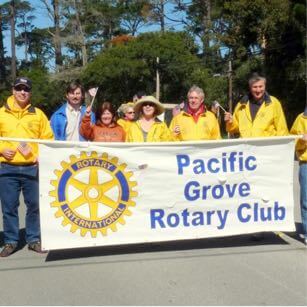 Rotary Club of Pacific Grove members holding a banner in a parade
